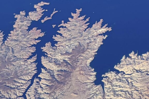 Abstract Landscape Fine Art titled Bluer Than Blue, an aerial view of a blue-water shoreline.