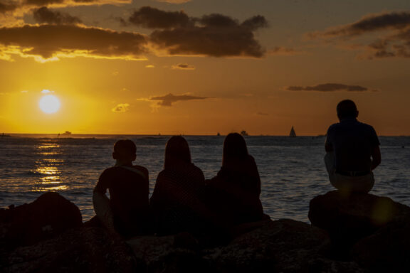 Coastal Landscape Fine Art titled Dreaming, featuring silhouettes of people watching a Honolulu sunset.